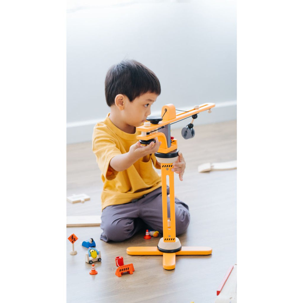 Kid playing PlanToys Crane Set