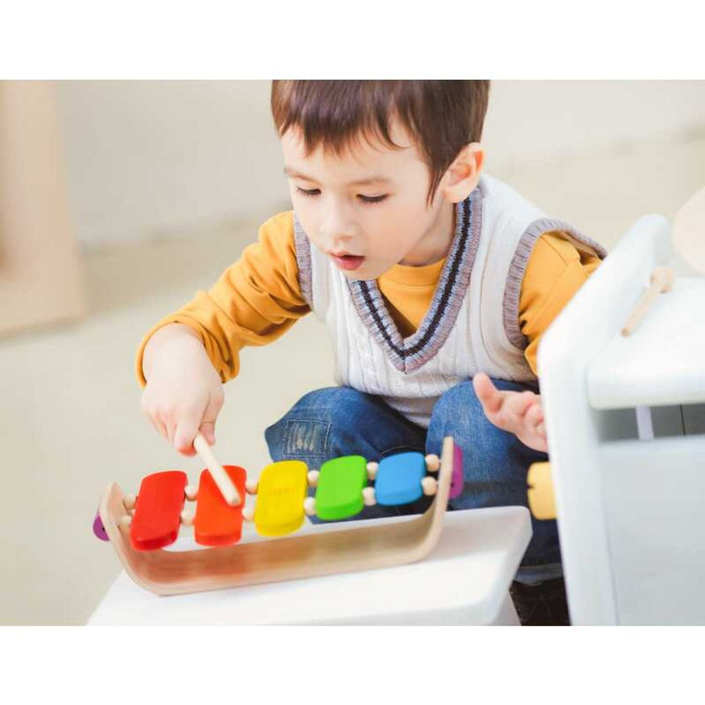 Kid playing PlanToys Oval Xylophone