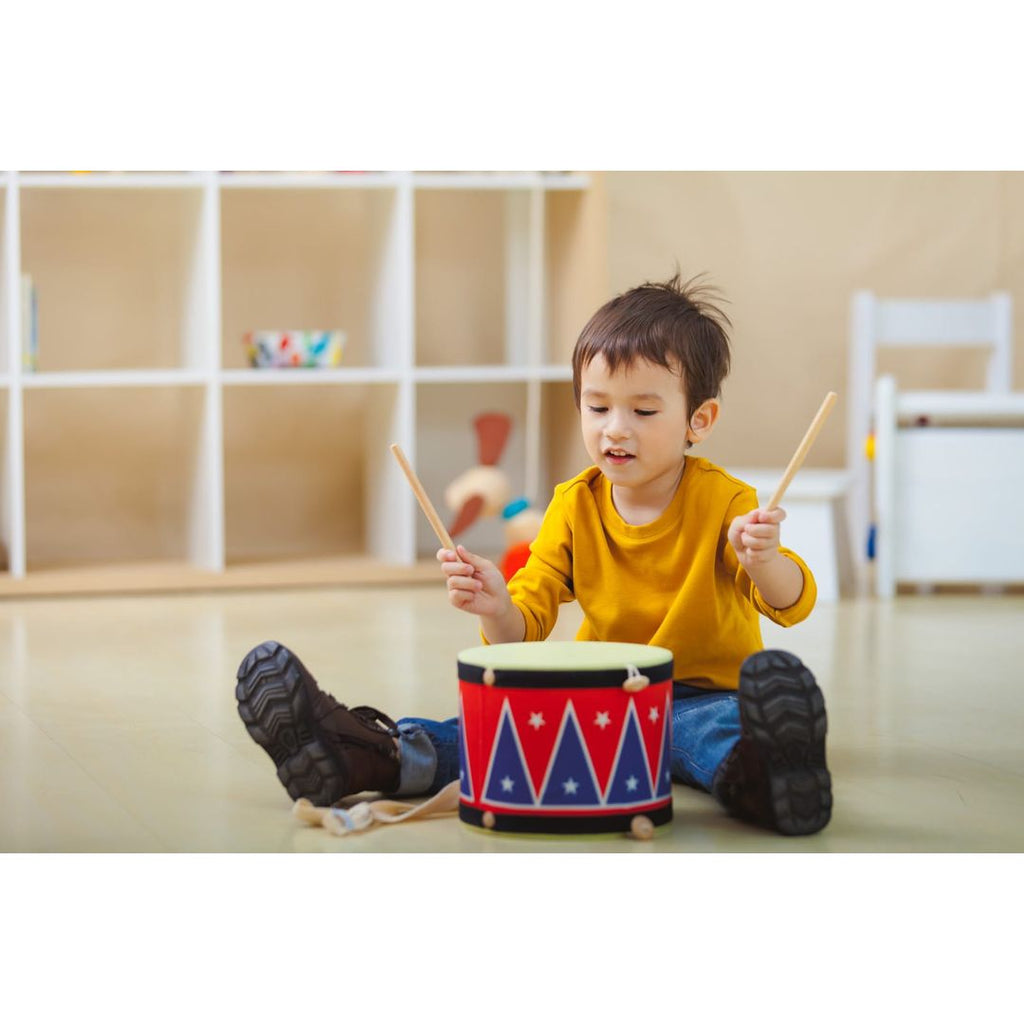 Kid playing PlanToys Big Drum II