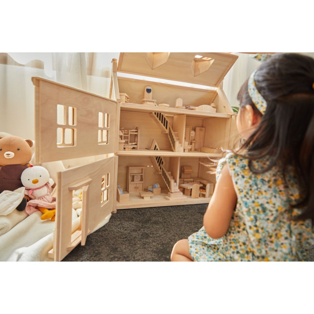 Kid playing PlanToys Victorian Dollhouse